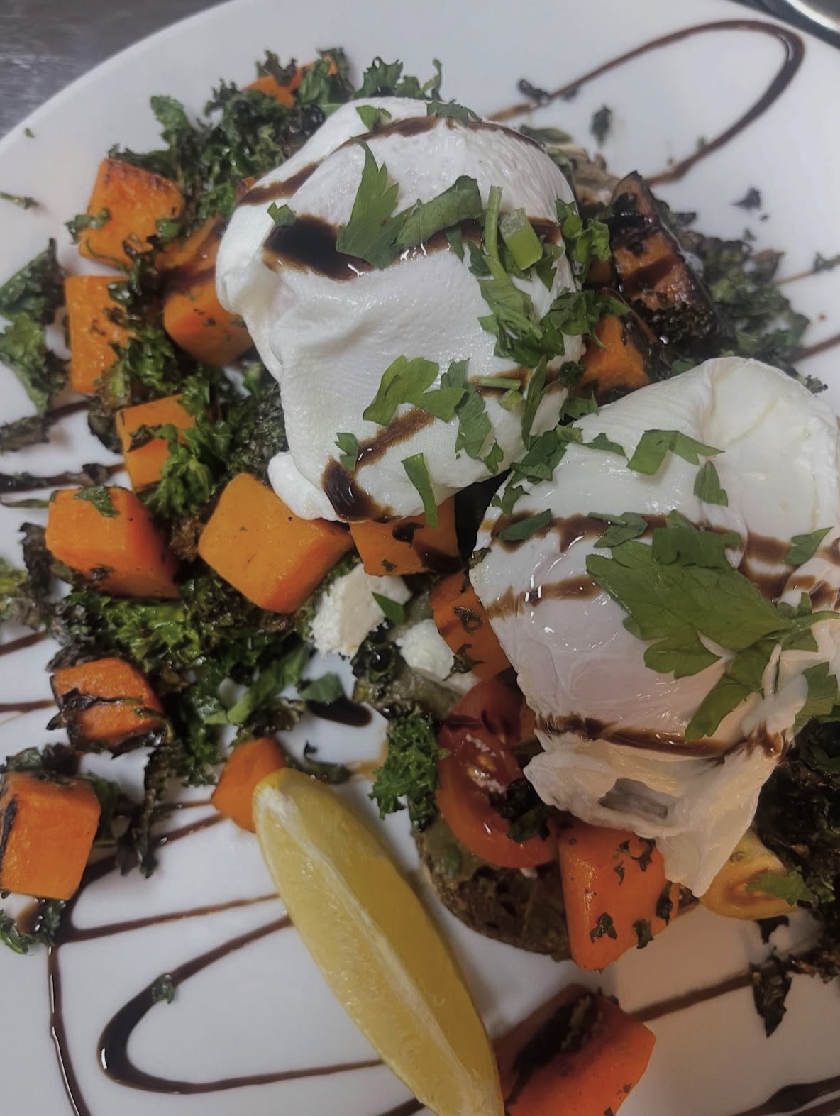 Poached eggs with roasted pumpkin, crispy kale and balsamic glaze